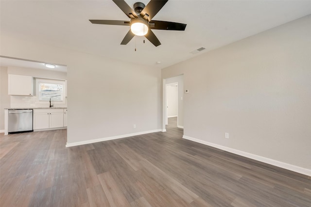 spare room with ceiling fan, sink, and wood-type flooring