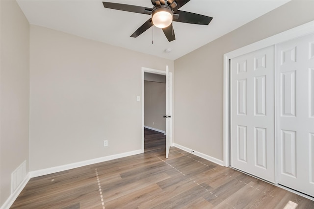 unfurnished bedroom featuring a closet, light hardwood / wood-style flooring, and ceiling fan