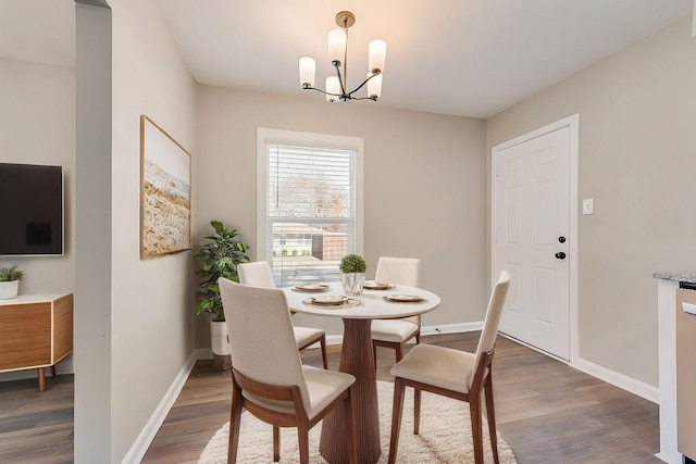 dining space featuring wood-type flooring and an inviting chandelier