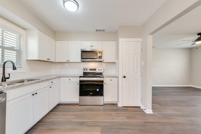 kitchen featuring white cabinetry, sink, stainless steel appliances, and light hardwood / wood-style flooring