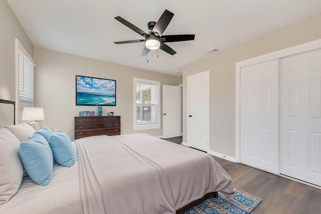 bedroom with ceiling fan, dark wood-type flooring, and a closet