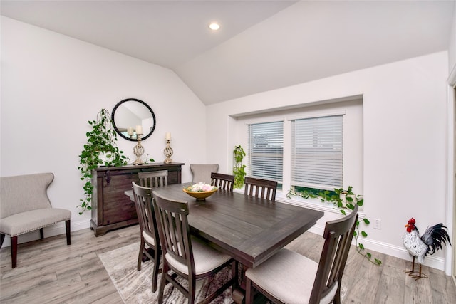 dining space with light hardwood / wood-style floors and lofted ceiling