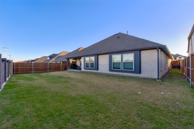 rear view of property featuring a yard