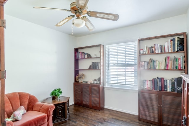 sitting room with dark wood-style floors, baseboards, and a ceiling fan