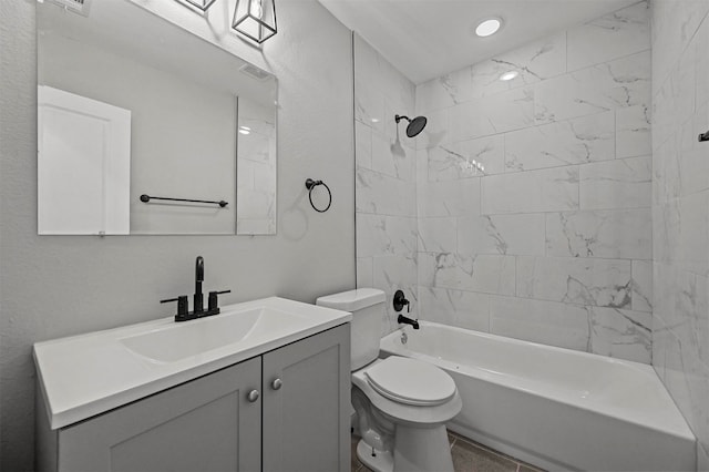 full bathroom featuring tiled shower / bath, vanity, and toilet