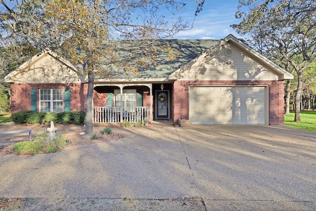 ranch-style home featuring covered porch and a garage