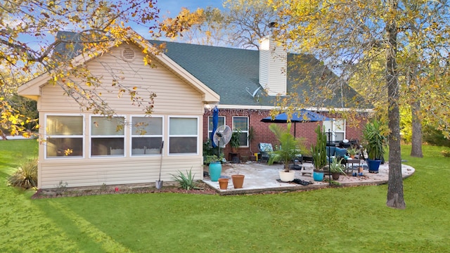 back of house with a lawn and a patio area