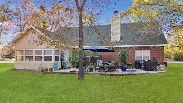 back of property featuring outdoor lounge area, a patio area, and a yard