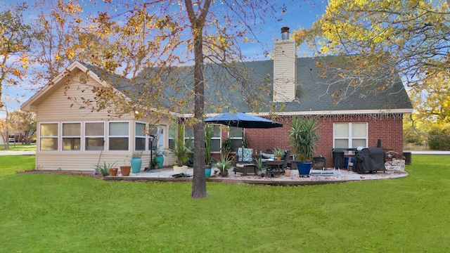 back of property featuring a lawn and a patio