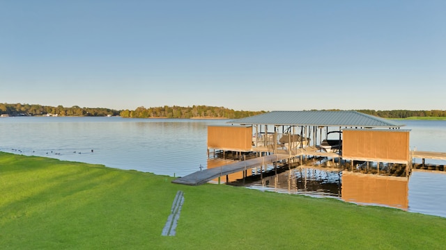 view of dock with a lawn and a water view