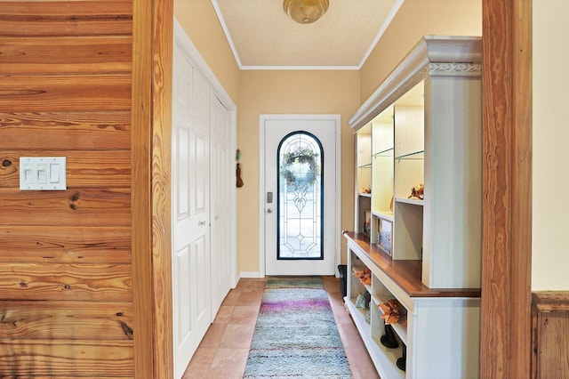 doorway with crown molding and light tile patterned floors