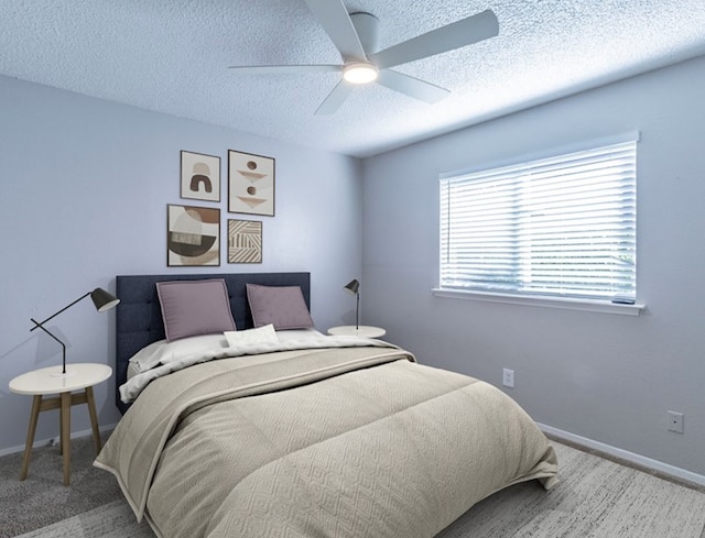 carpeted bedroom with a textured ceiling and ceiling fan