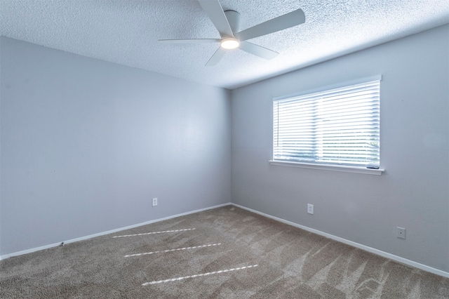 carpeted spare room featuring a textured ceiling and ceiling fan