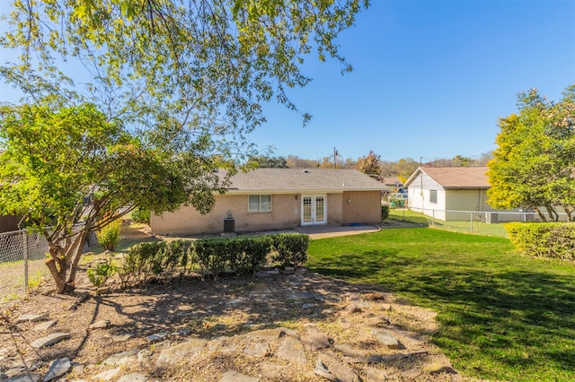 back of property with french doors, a patio, and a lawn