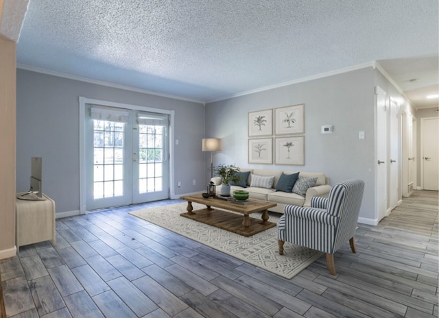 living room featuring crown molding, light wood-type flooring, a textured ceiling, and french doors