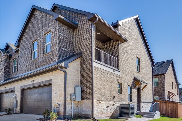 view of home's exterior featuring a garage, central air condition unit, and a balcony