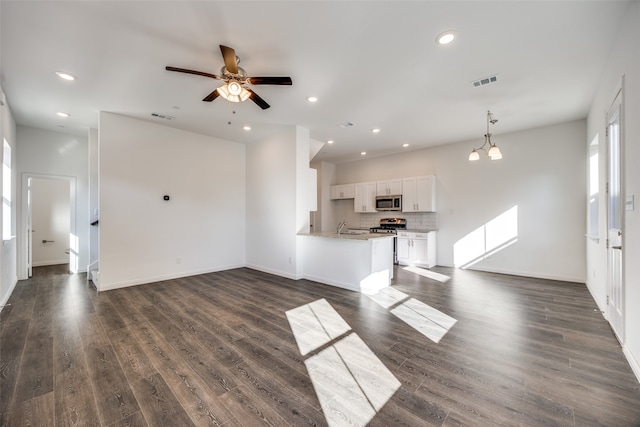 unfurnished living room with dark hardwood / wood-style flooring, sink, and ceiling fan with notable chandelier