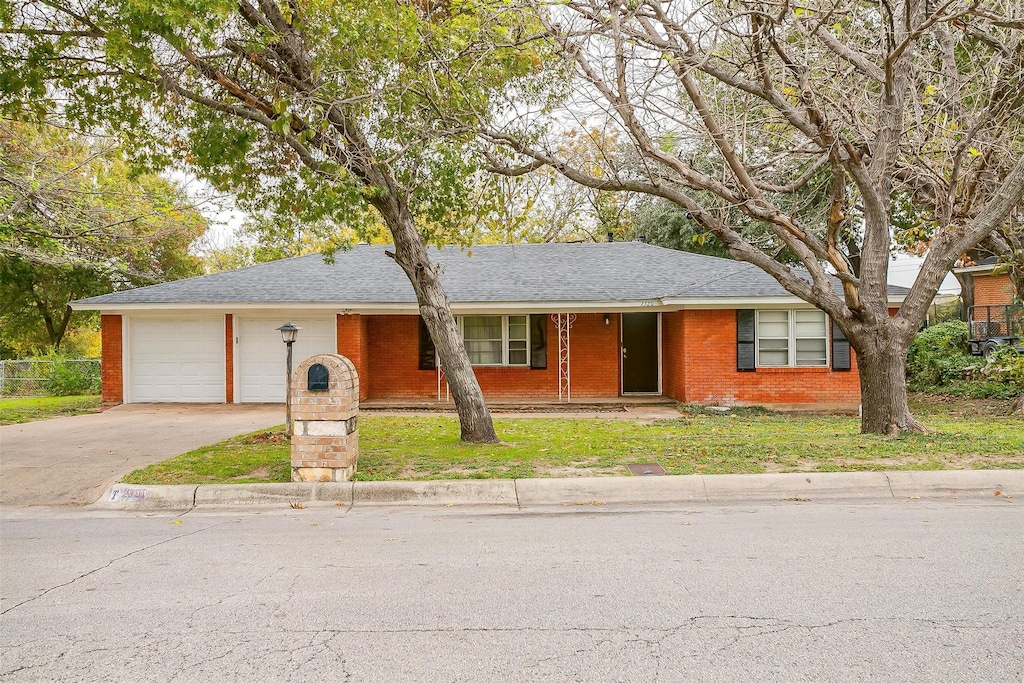 single story home featuring a garage and a front yard