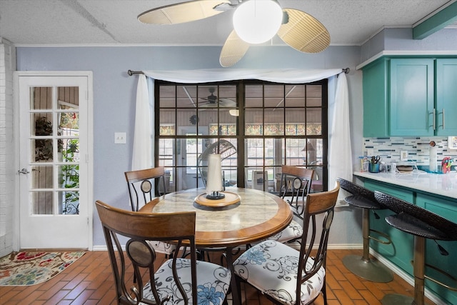 1208 Lexington Sq, Corsicana, TX 75110 - dining area featuring brick flooring, ornamental molding, a ceiling fan, a textured ceiling, and plenty of natural light
