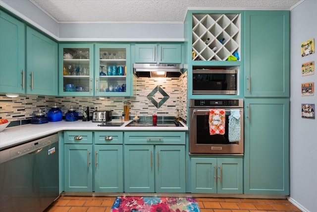 kitchen with appliances with stainless steel finishes, tasteful backsplash, a textured ceiling, light tile patterned floors, and green cabinets