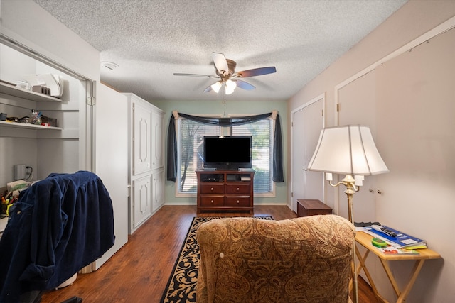 interior space with a textured ceiling, dark hardwood / wood-style floors, and ceiling fan