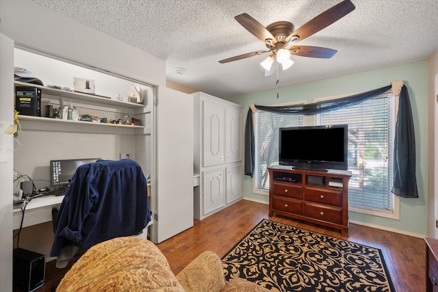 home office featuring hardwood / wood-style flooring, ceiling fan, and a textured ceiling