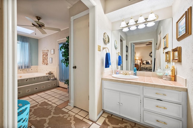 bathroom with tile patterned flooring, vanity, ceiling fan, and a skylight