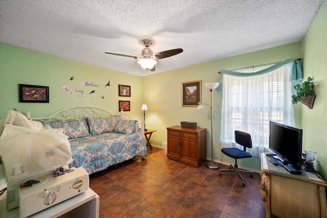 bedroom with ceiling fan and a textured ceiling