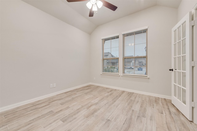 empty room featuring ceiling fan, lofted ceiling, and light hardwood / wood-style flooring