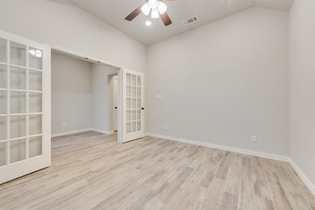 spare room featuring french doors, ceiling fan, vaulted ceiling, and light hardwood / wood-style flooring