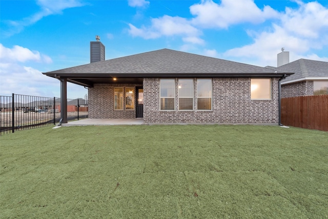 rear view of house with a patio area and a lawn