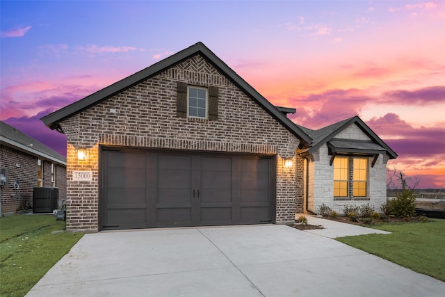 front of property featuring cooling unit, a garage, and a lawn