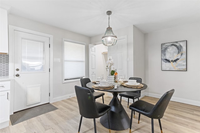 dining area featuring a notable chandelier and light wood-type flooring