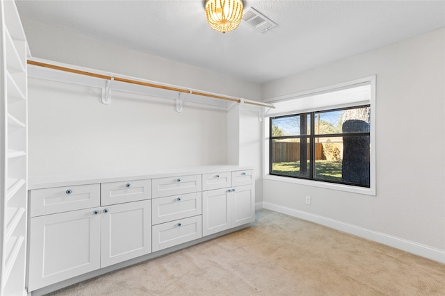 walk in closet featuring light carpet