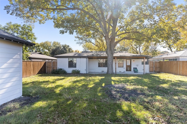 rear view of property with a yard