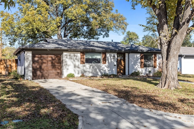 ranch-style home with a garage and a front yard