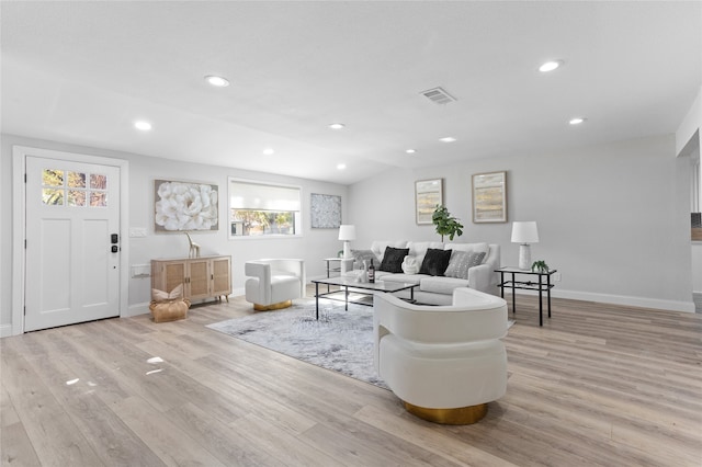 living room featuring vaulted ceiling and light hardwood / wood-style floors