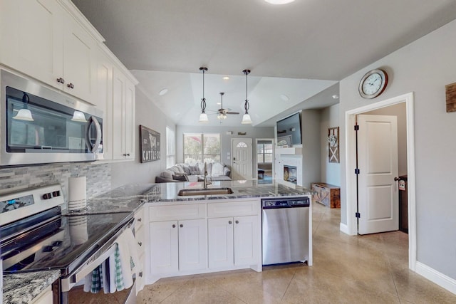 kitchen featuring stainless steel appliances, white cabinetry, lofted ceiling, and sink