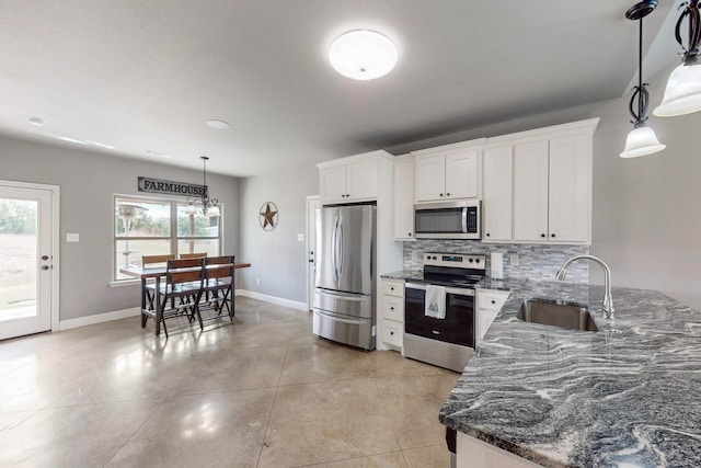 kitchen featuring decorative light fixtures, white cabinetry, sink, and appliances with stainless steel finishes