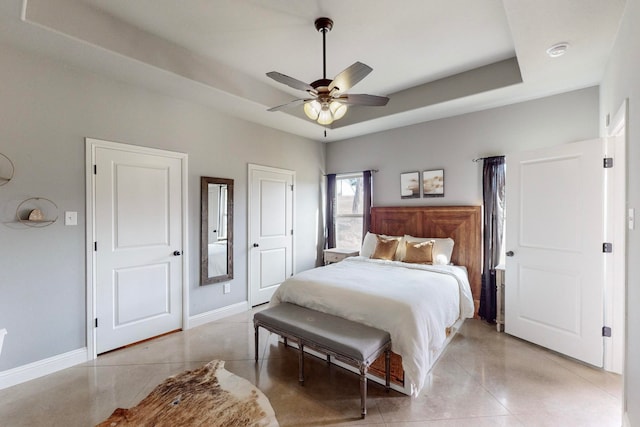 bedroom featuring ceiling fan and a tray ceiling