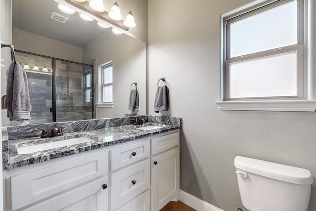 bathroom featuring toilet, vanity, and walk in shower