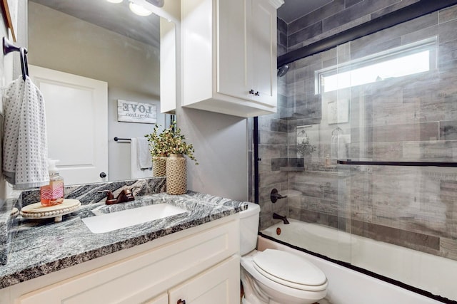 full bathroom featuring vanity, toilet, and enclosed tub / shower combo