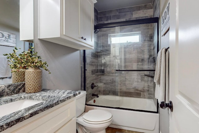 full bathroom with vanity, toilet, and bath / shower combo with glass door