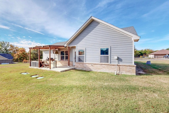 back of property with a lawn and a patio area