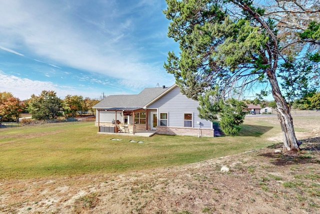 back of house with a lawn and a patio