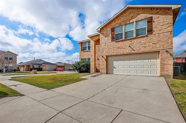 view of property featuring central AC unit, a garage, and a front lawn