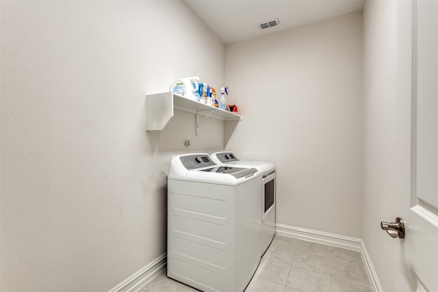 laundry room with light tile patterned flooring and washer and dryer