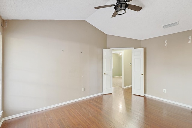 unfurnished room featuring wood-type flooring, ceiling fan, and vaulted ceiling