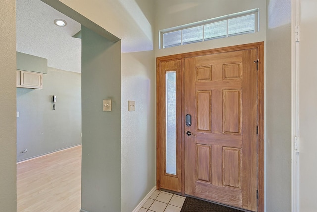 tiled foyer entrance with a textured ceiling