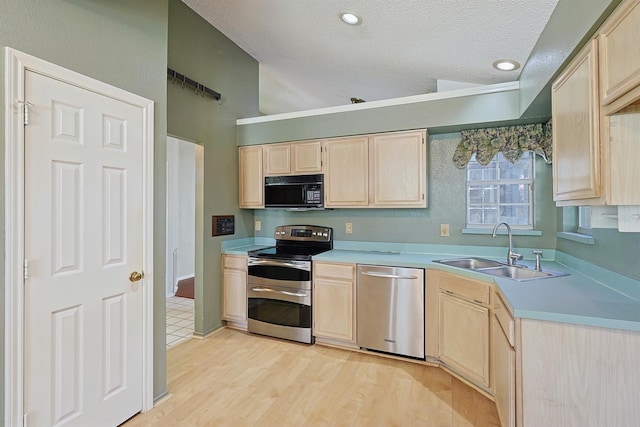 kitchen with appliances with stainless steel finishes, sink, and light brown cabinets